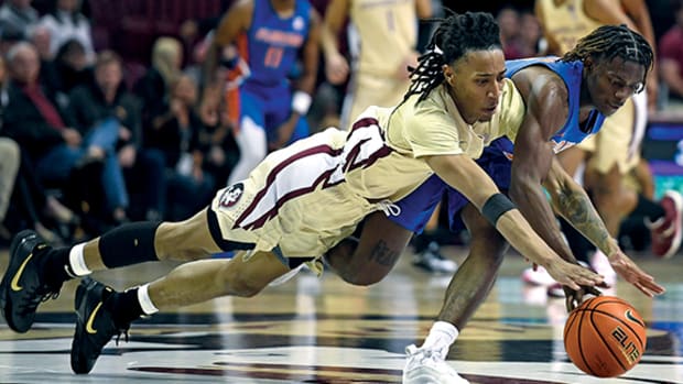 Florida State Seminoles guard Caleb Mills and Florida Gators forward Trey Bonham dive for a loose ball during the second half at Donald L. Tucker Center.